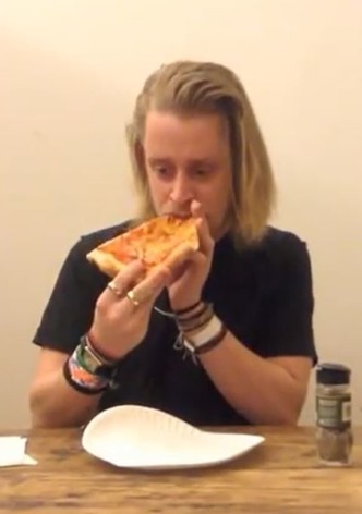 Macaulay Culkin Eating a Slice of Pizza