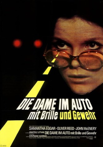 Die Dame im Auto mit Brille und Gewehr